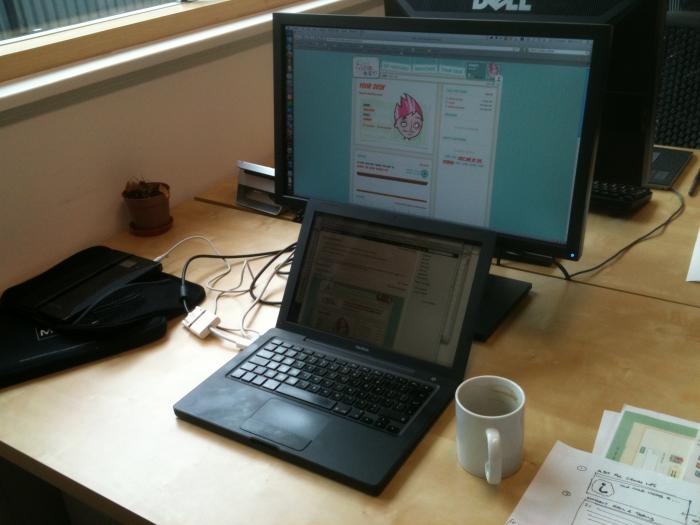 MacBook on a desk next to a desktop monitor