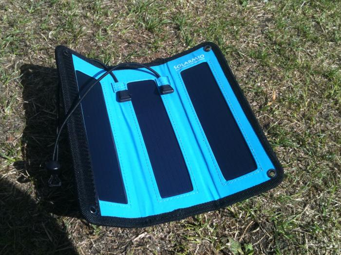 Blue folding solar charger opened out on the grass