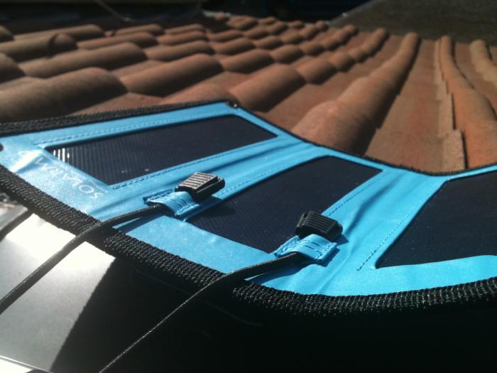 Blue folding solar charger laid out on roof tiles
