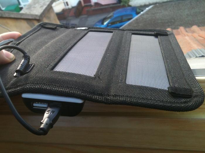 Black folding solar charger connected to a battery pack