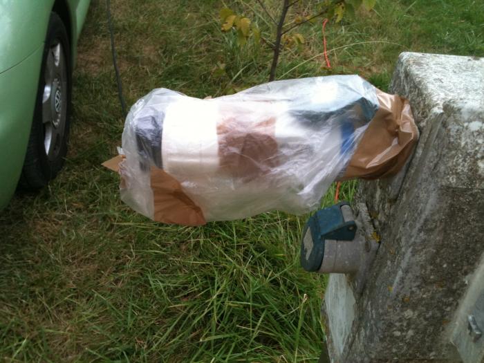 Bag of supplies hanging on a post beside the car