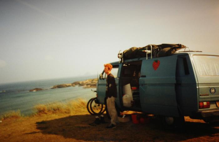 Blue T25 panel van parked above the sea in evening light