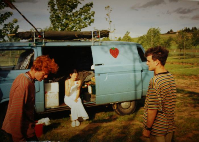 Friends chatting by the open side door of the blue T25 panel van