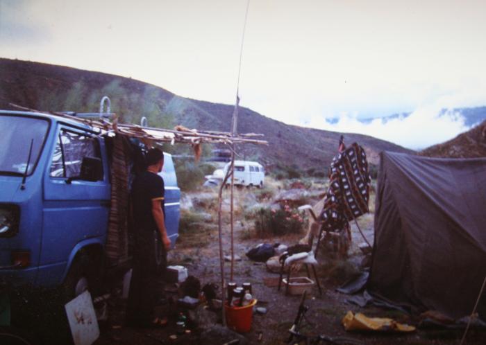Camp set up beside the blue T25 panel van, with a tent and washing line