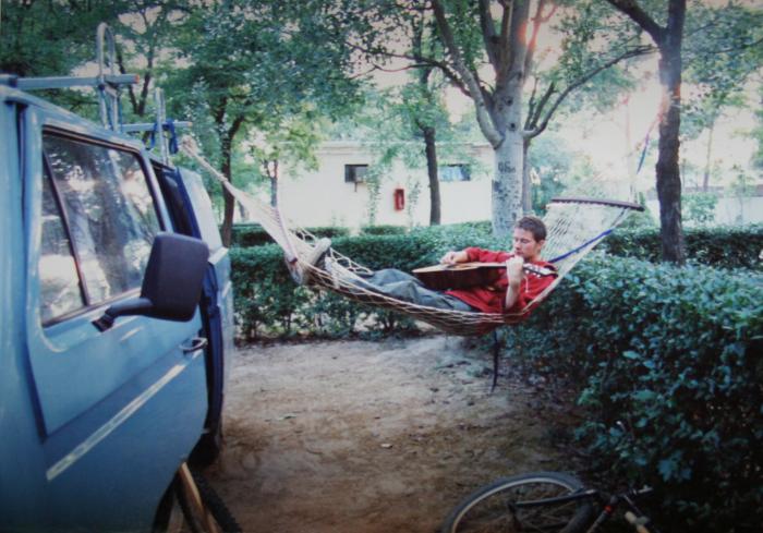 Relaxing in a hammock strung from the blue T25 panel van