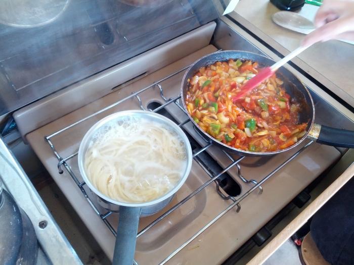 Cooking pasta and sauce on the camper's stove