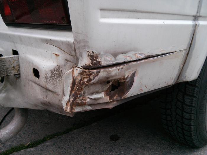 Rusted corner panel by the rear wheel