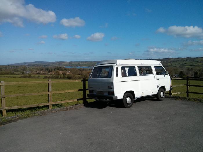 White T25 parked at a viewpoint over the countryside