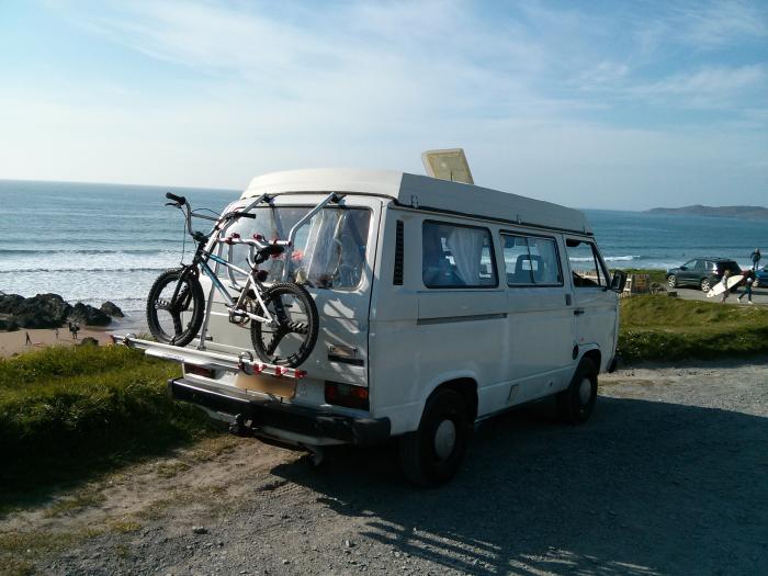 T25 with a bike on the back parked above the beach