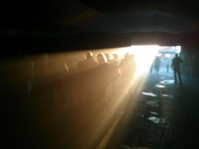 People walking through a sunlit tunnel at the festival