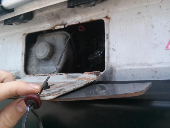 Fitting the dipstick by the engine hatch