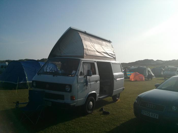 T25 with the pop top up at a busy campsite
