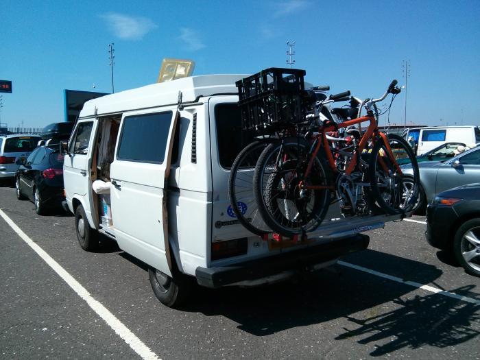 White VW T25 camper with bikes on the back in the ferry port car park