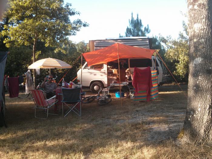 Camp set up under an orange canopy beside the T25 among the trees