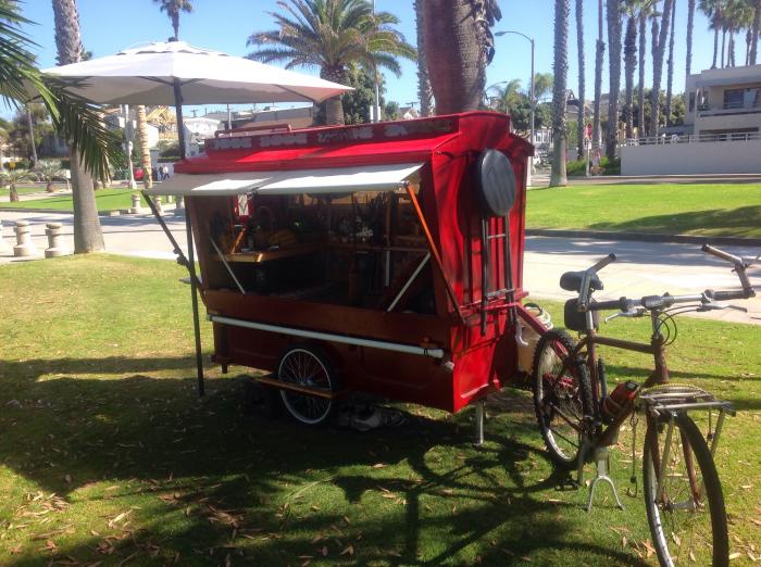 Bicycle towing a tiny red camper