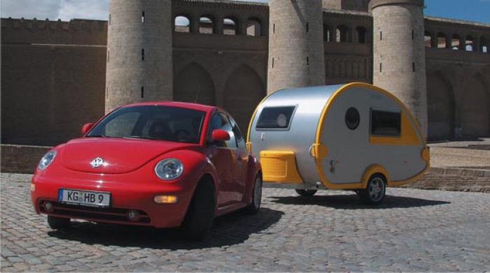 Red New Beetle towing a teardrop caravan