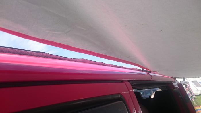 Tarp stretched out from the side of the van